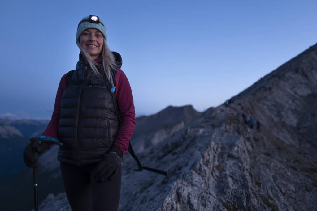 Young woman hiking on mountain trail near Berlin, enjoying outdoor adventure.
