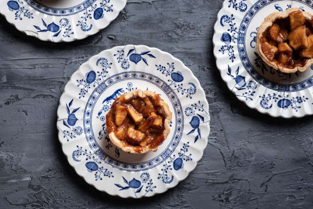 Delicious caramelised apple tart served on elegant blue and white porcelain plates. Perfect for dess.