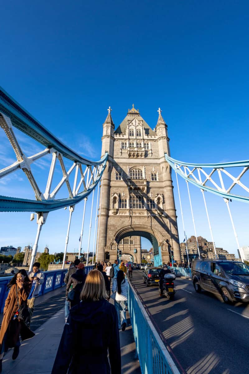 Tower Bridge in London with pedestrians and vehicles on the bridge.
