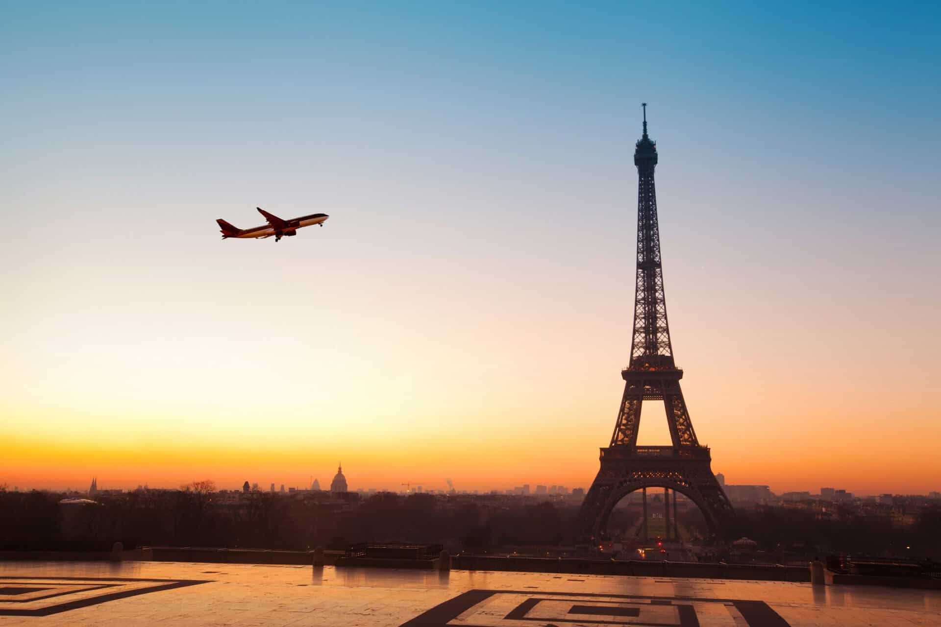 Eiffel Tower with airplane flying in sunset sky, Paris landmark, travel, tourism, cityscape, iconic.