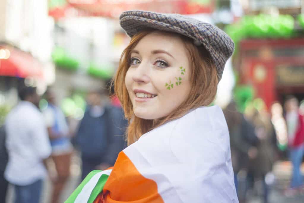 Young woman with Irish flag and shamrock face paint in Mitte, Berlin.
