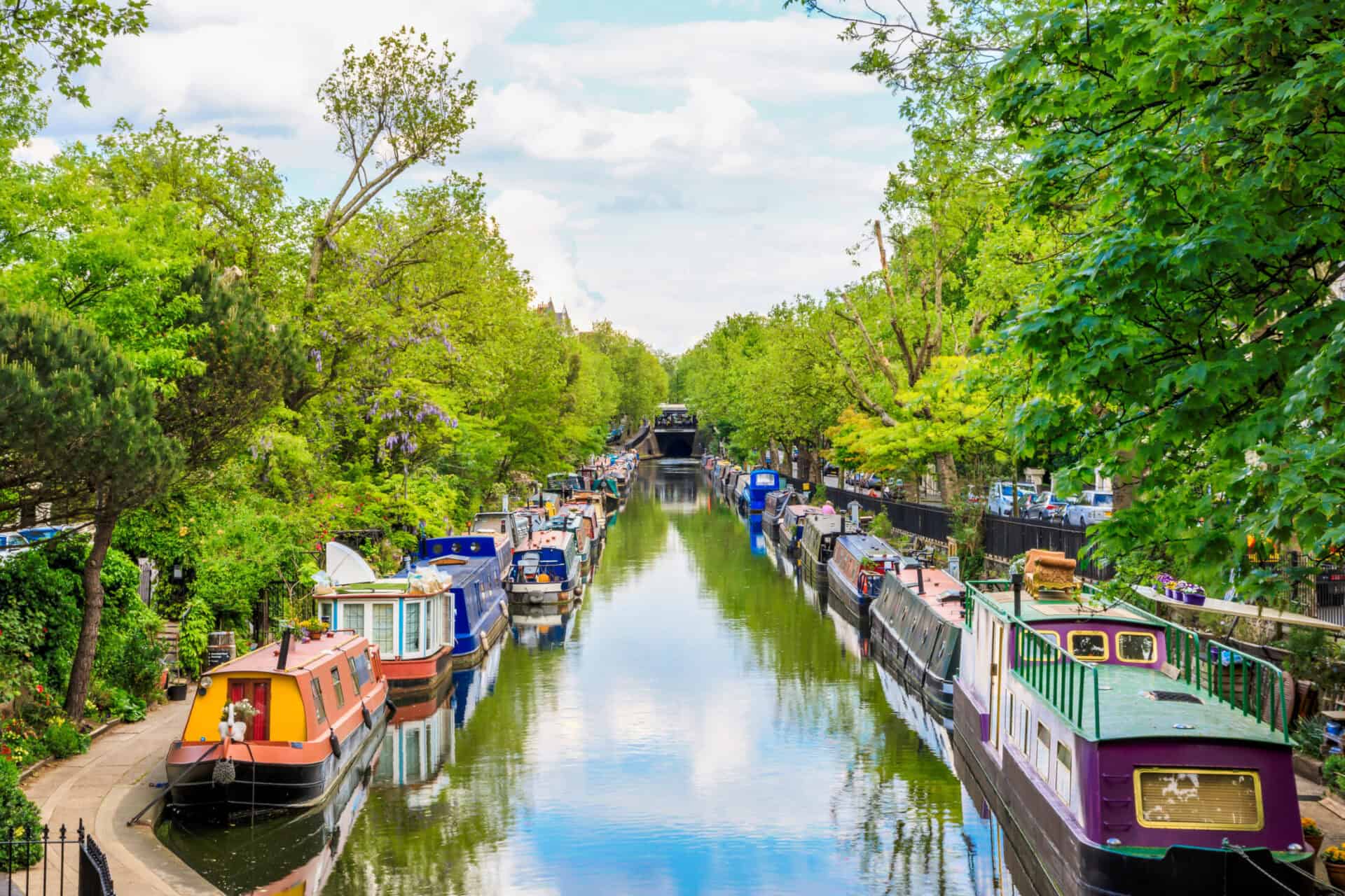 Historic canal with boats and lush greenery in Berlin Mitte.