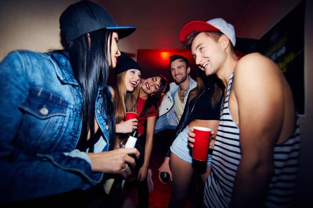 Group of young friends enjoying drinks at a lively hostel party in Berlin Mitte.