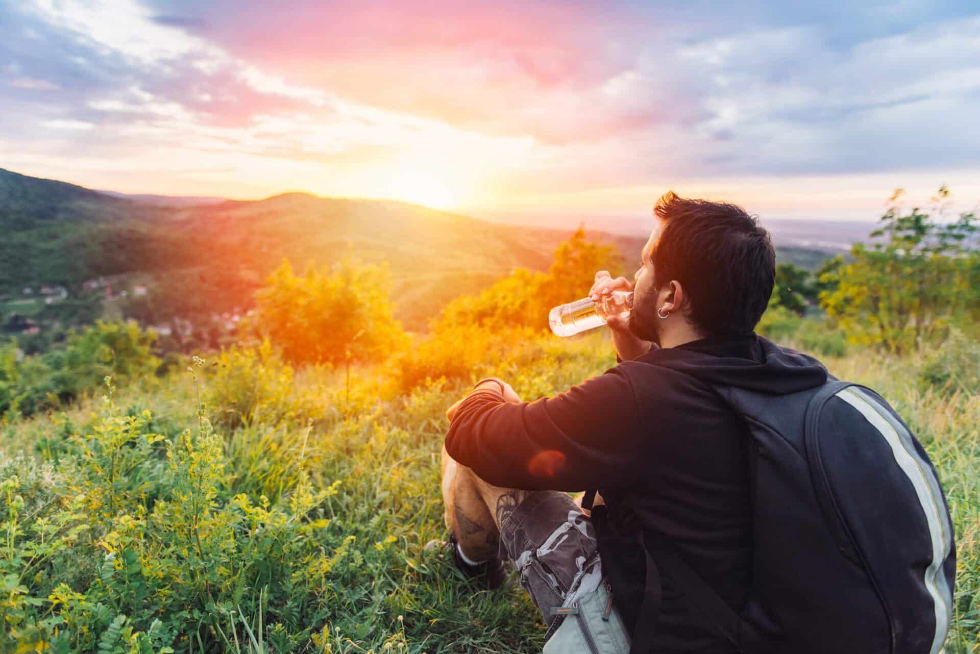 Young man enjoying sunset view in Berlin's Mitte district with backpack.