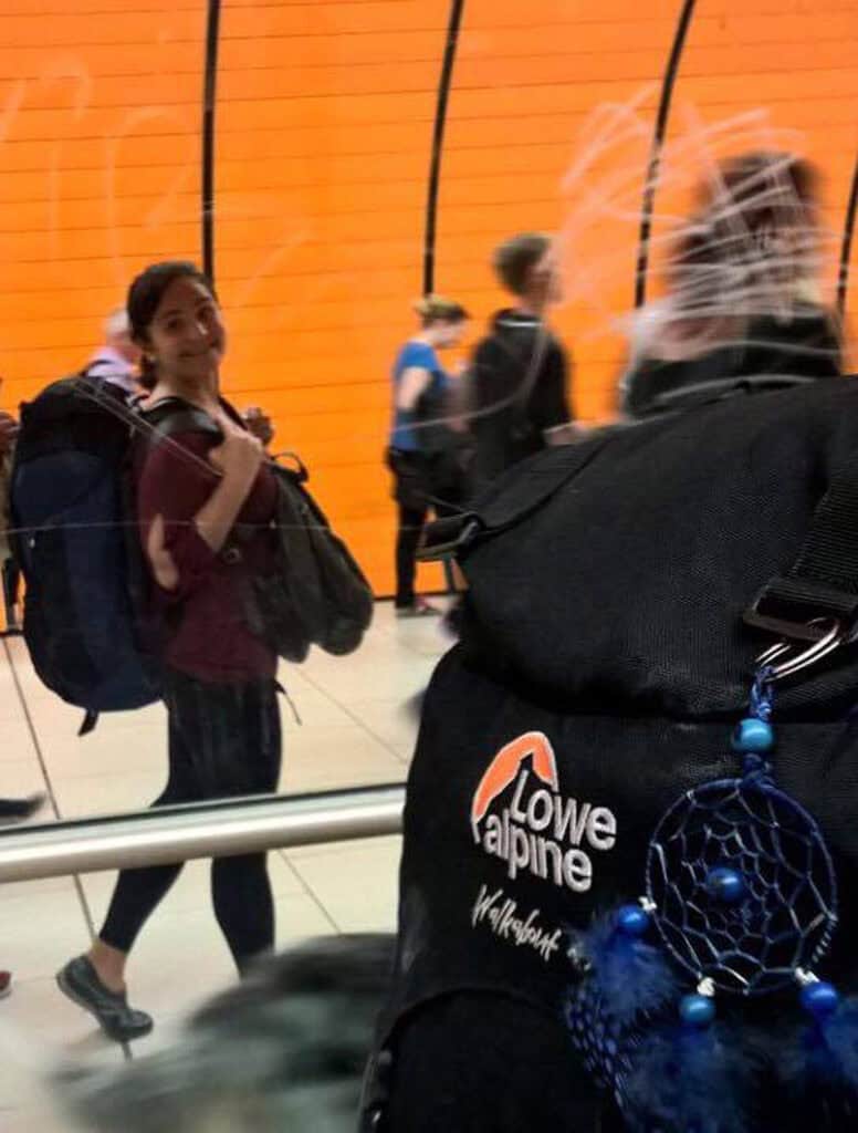 Young woman with backpack at Berlin Mitte Hostel check-in area.
