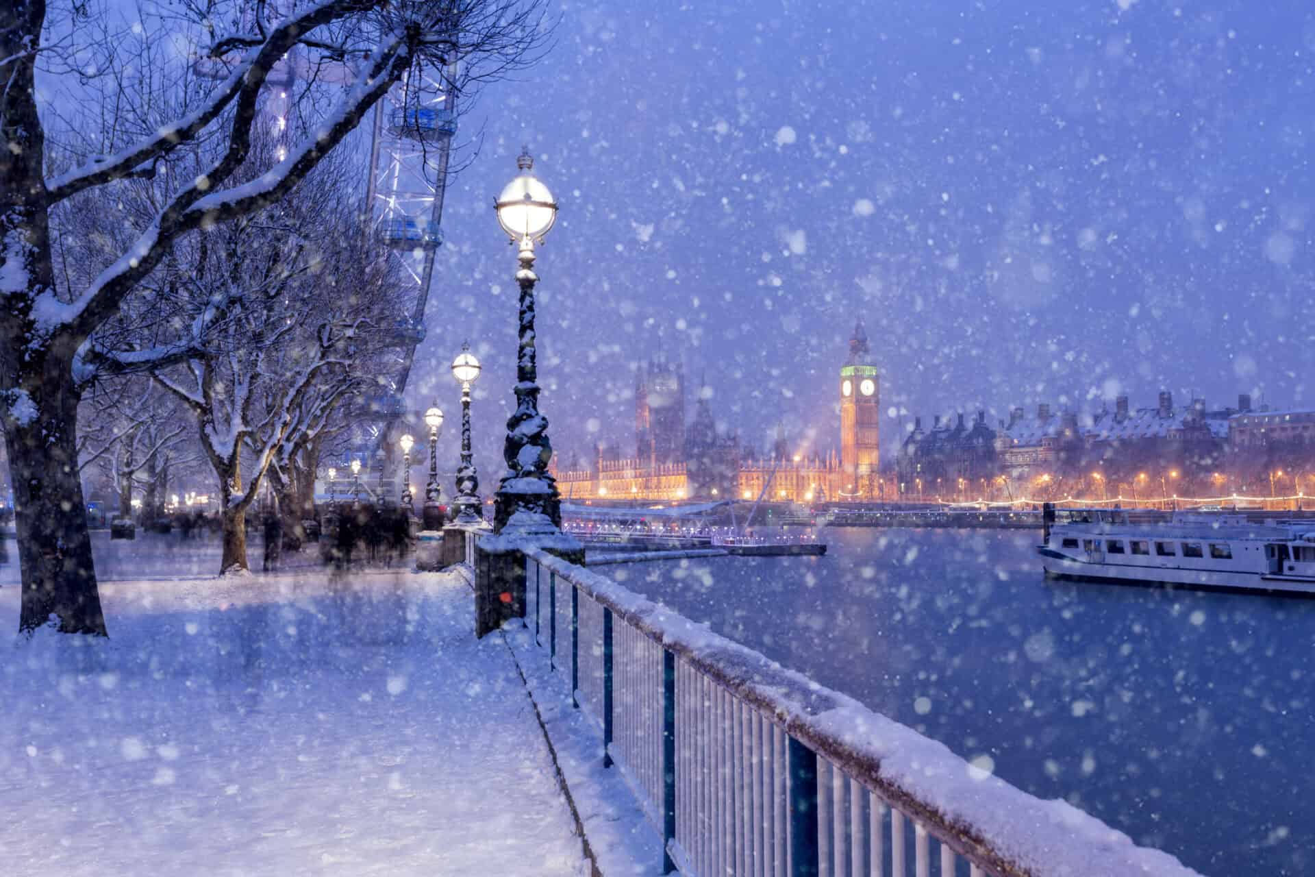 Snowy winter scene along the Spree River in Berlin, with illuminated lamps and historic buildings in.