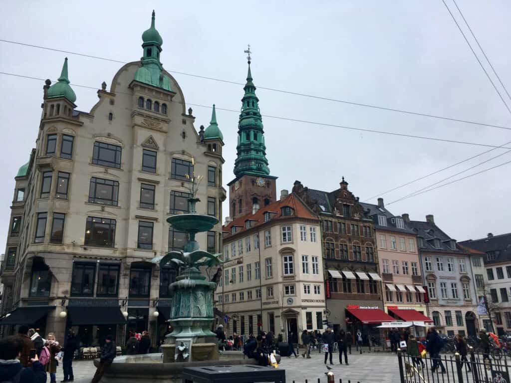 Historic Berlin city square with ornate buildings and a central fountain.