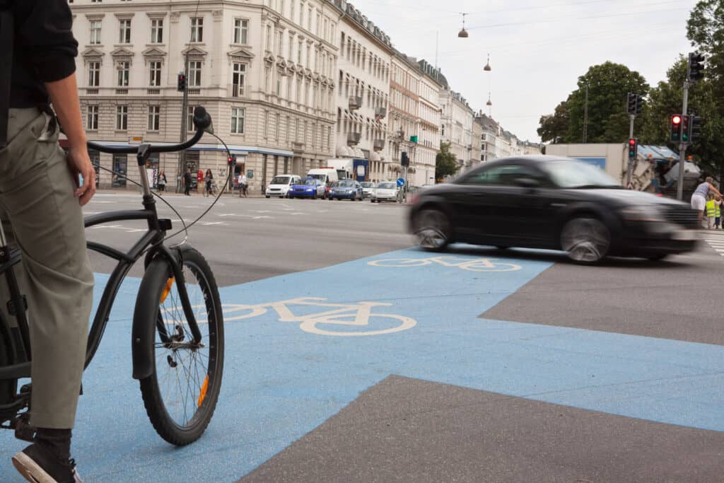Bicycle lane in Berlin Mitte with cyclist and city traffic, urban scene.