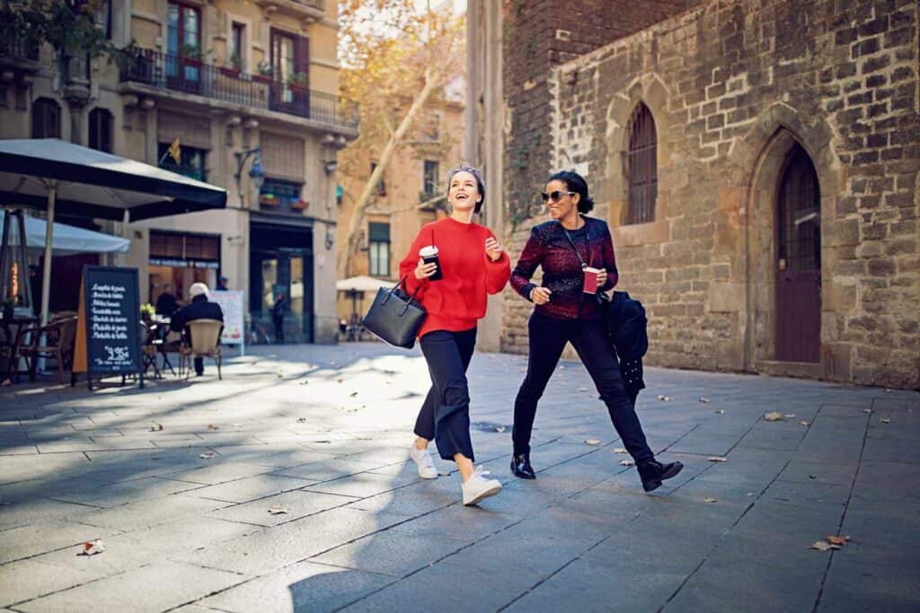 Two women walking in Berlin Mitte, enjoying the city atmosphere.