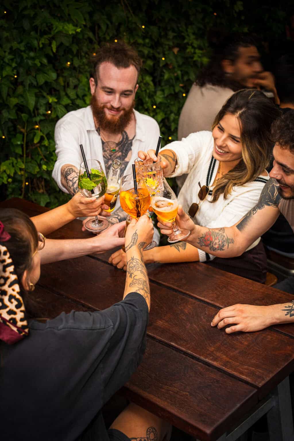A lively social hostel bar with friends enjoying drinks and conversation.