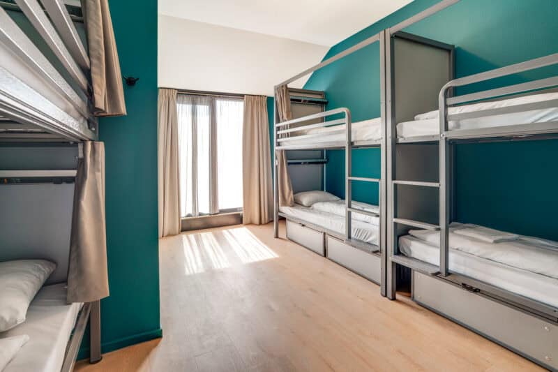 A dorm room in a St Christopher's Inn with bunk beds and a large window.
