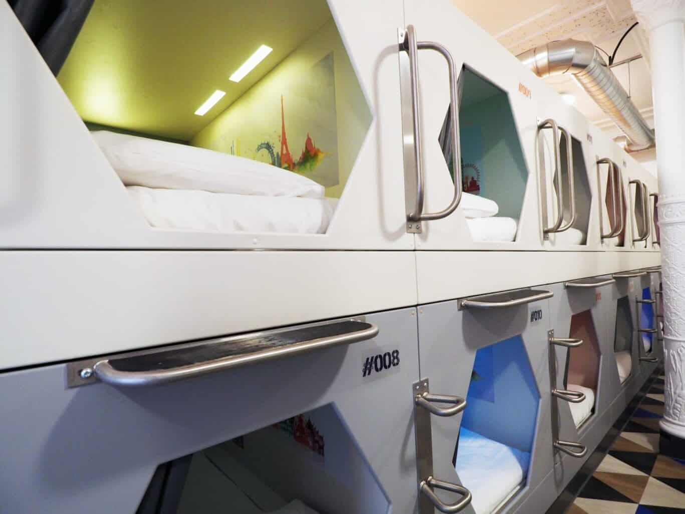 A modern bunk bed in a St Christopher's Inn dorm with a colourful mural in the background.