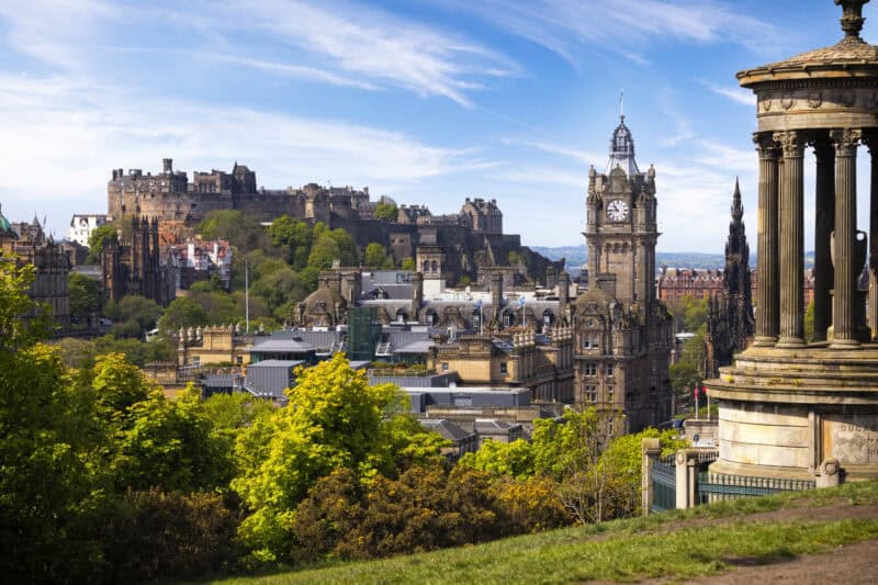 Panoramic view of historic buildings and a clock tower in a cityscape.