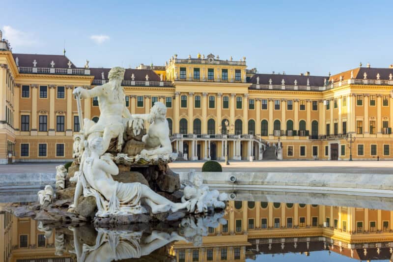 Grand Palace and fountain with ornate sculptures in Vienna, Austria.
