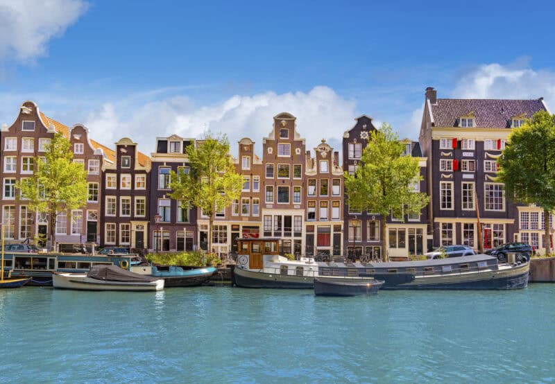 Colourful canal houses and boats in a European city.