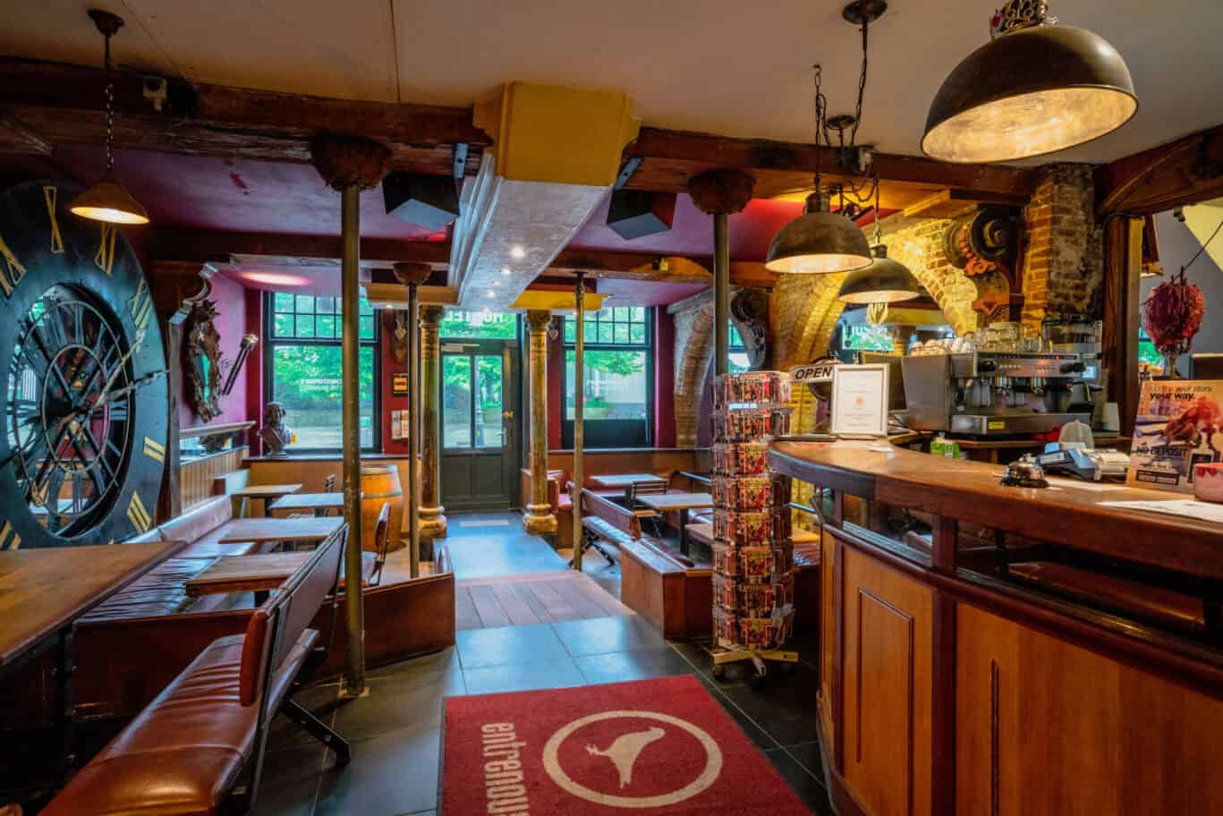 A busy social hostel bar with seating and a bar counter, warm lighting, and decorative elements.