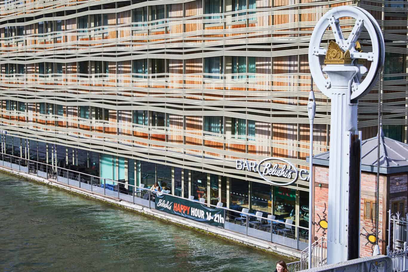 Exterior view of a Belushi's bar in a modern riverside building.