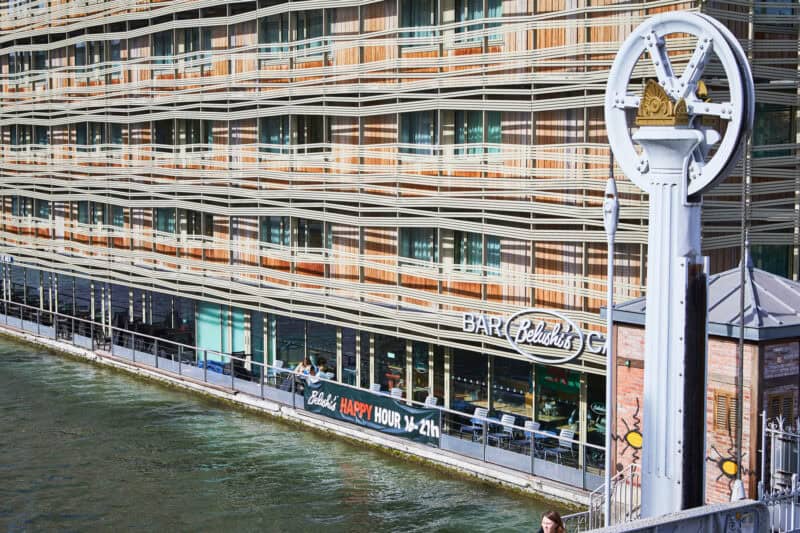 Exterior view of a Belushi's bar in a modern riverside building.