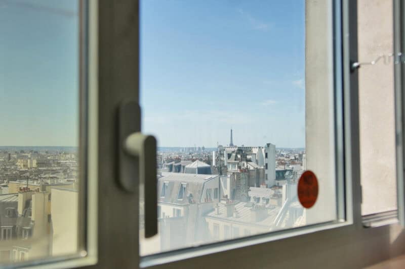 View of city rooftops and skyline from a dorm window in a St Christopher's Inn.