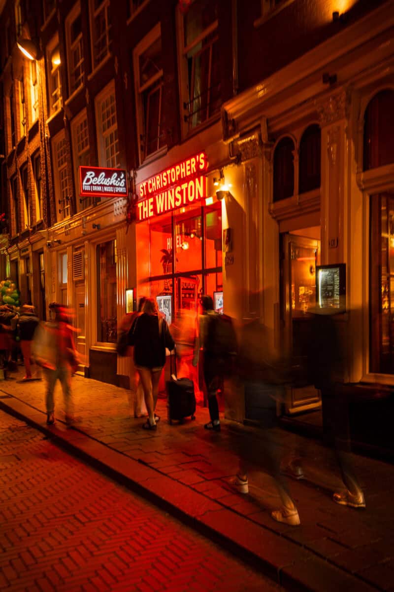 Night scene outside St Christopher's The Winston with people entering the venue at night.