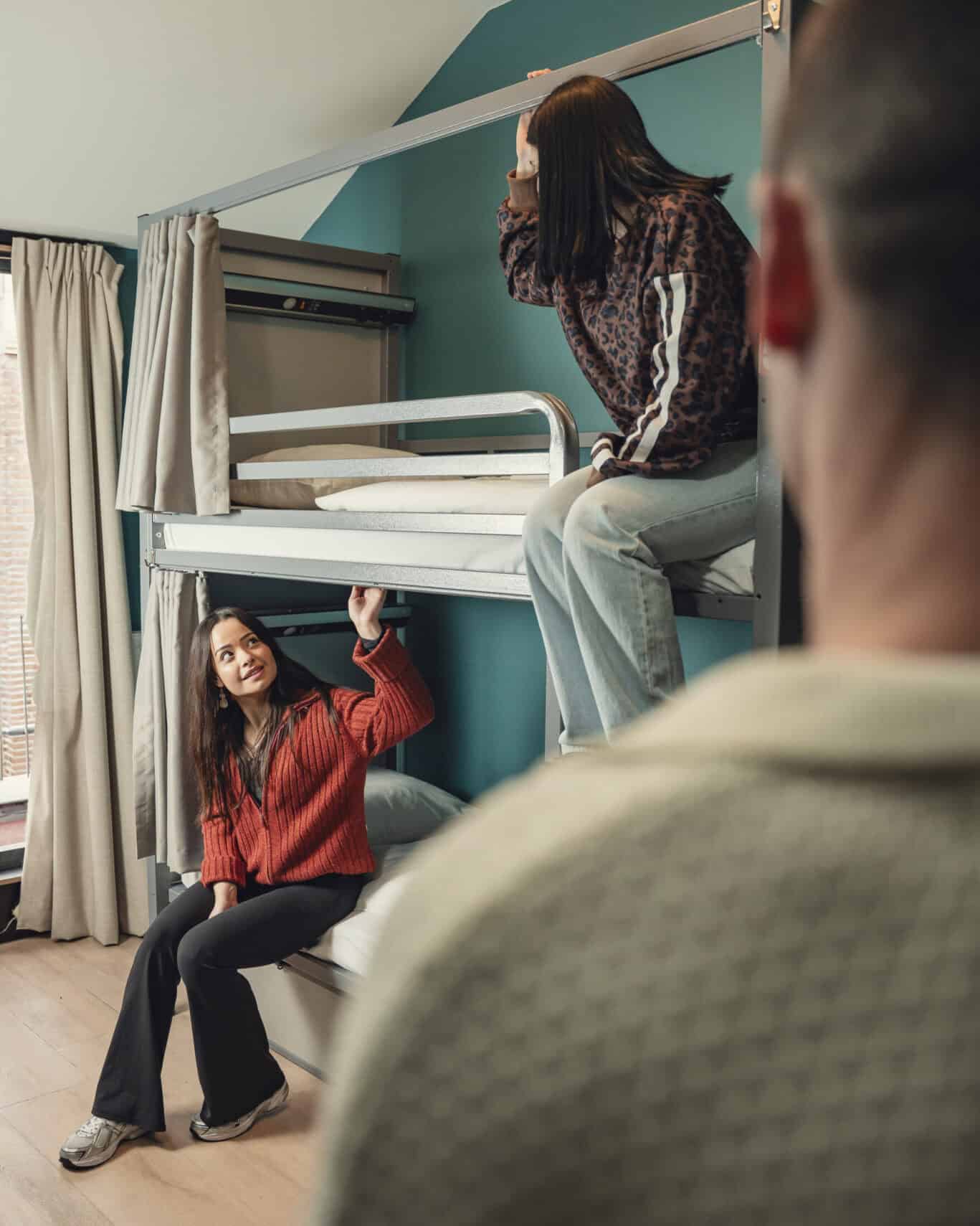 Hostel dorm at St Christopher's Berlin Mitte showing bunk beds and travellers relaxing.