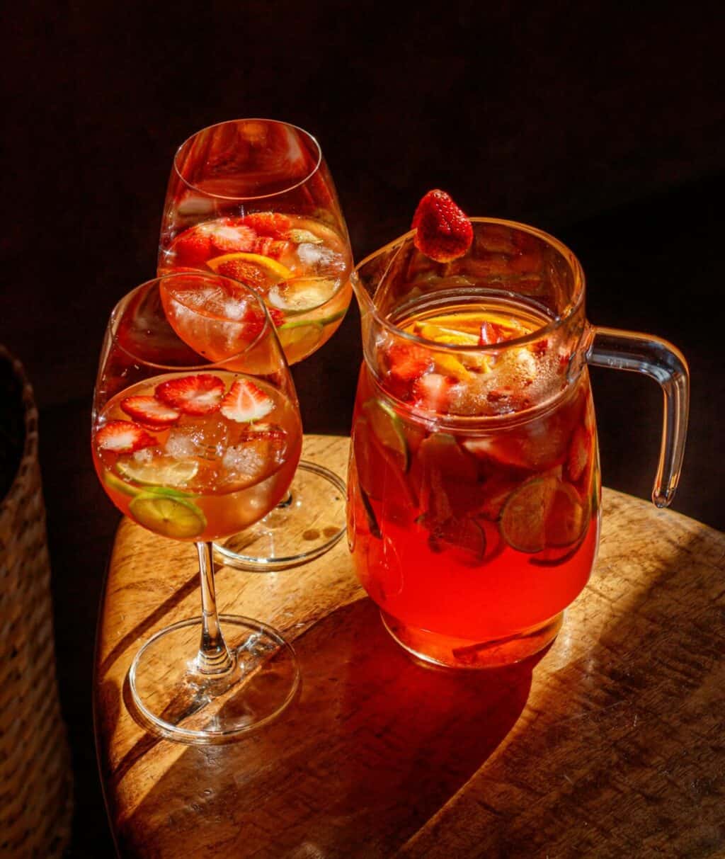 A social space in a St Christopher's Inn with a pitcher and glasses of sangria on a wooden surface.