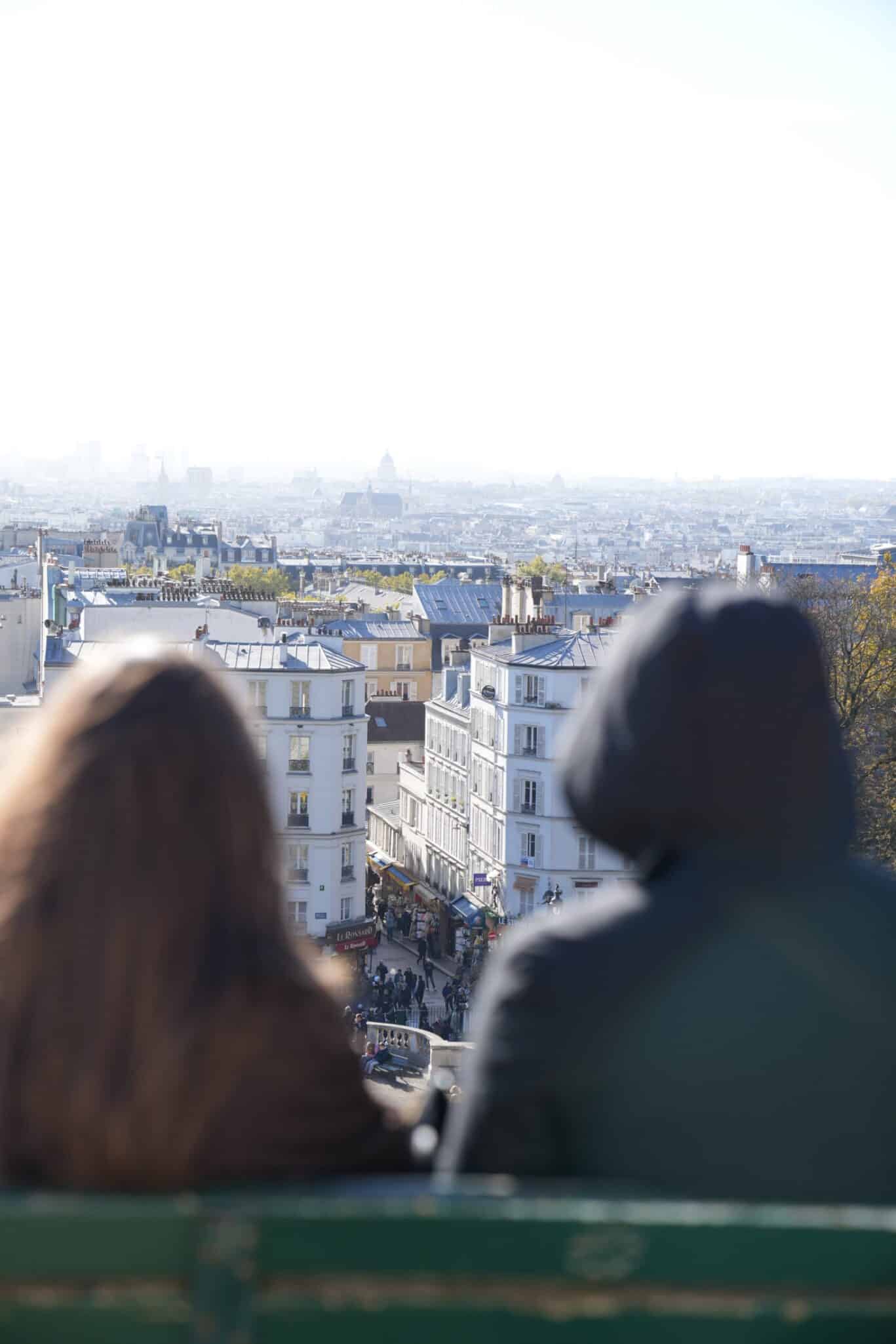 Two people overlooking a cityscape from a high vantage point.