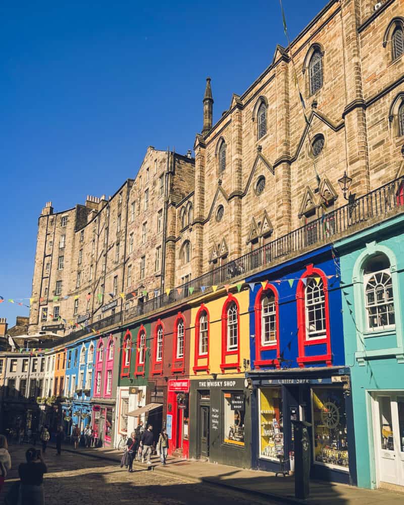 A lively street with colourful shops and pedestrians in a European city.