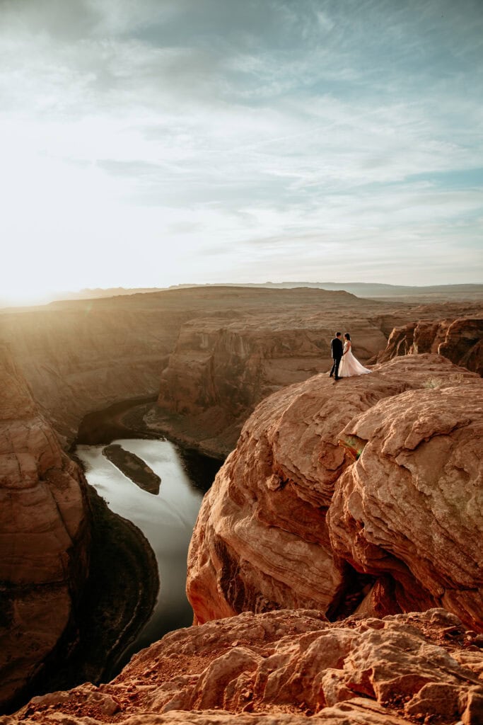 Couple standing overlooking Horseshoe Bend during sunset at their Arizona elopement by Stratus Photography