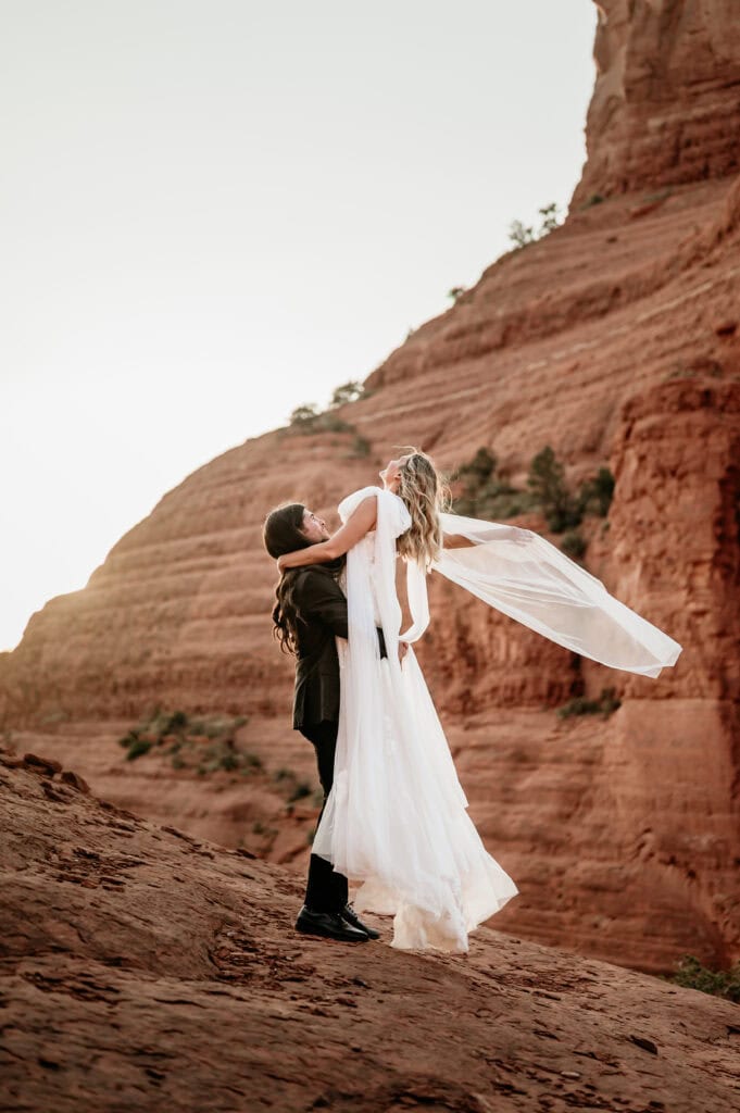 groom lifting bride in the air during their Sedona Arizona elopement by Stratus Adventure Photography