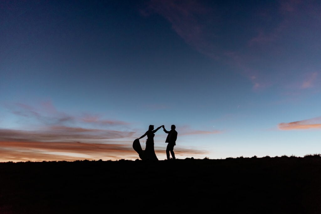 Silhouettes of eloping couple dancing in the light of the sunset during their northern Arizona elopement 
