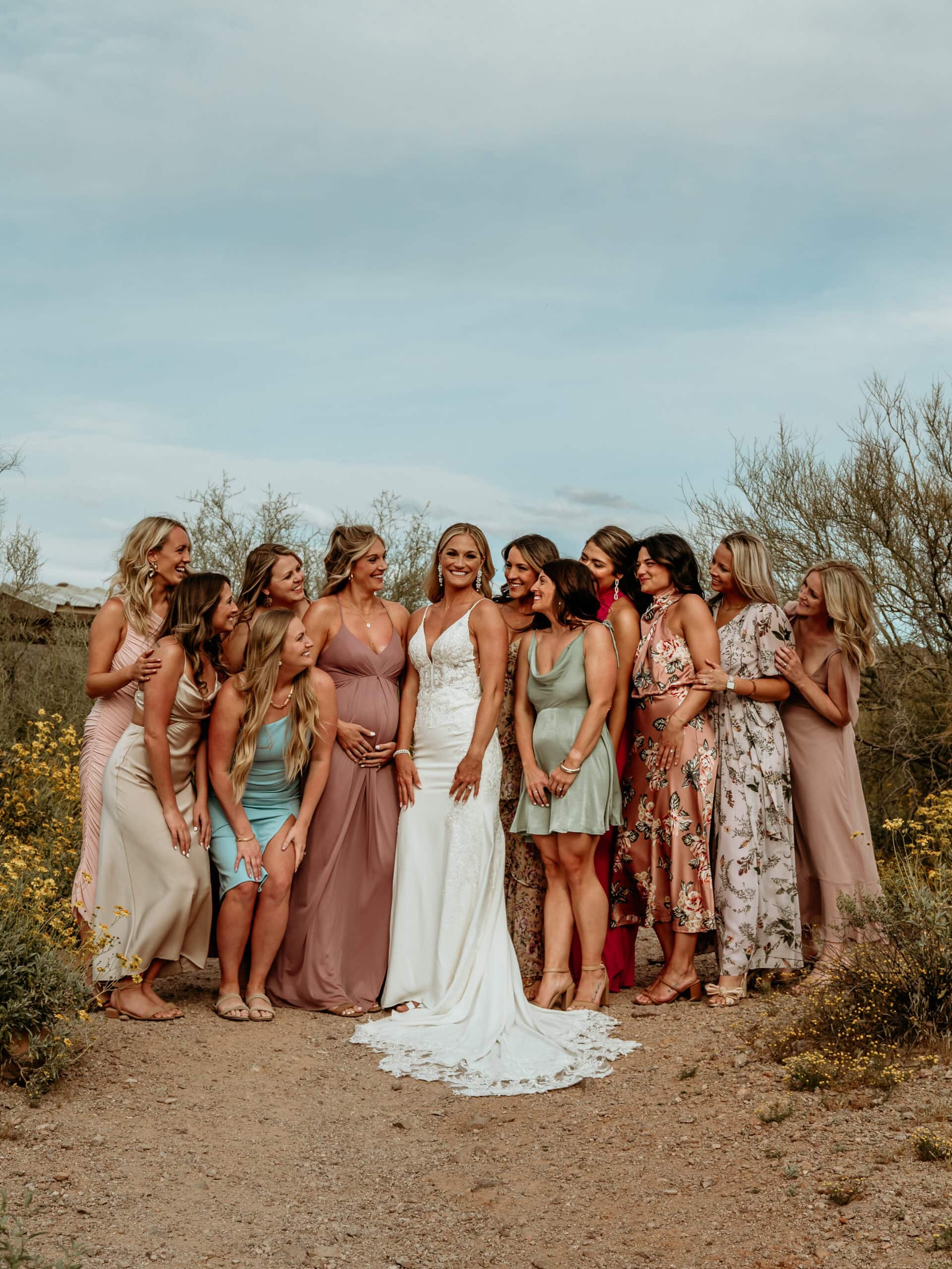 Bride surrounded by all the ladies for her elopement in gorgeous sun dresses in varying complimentary colors and prints