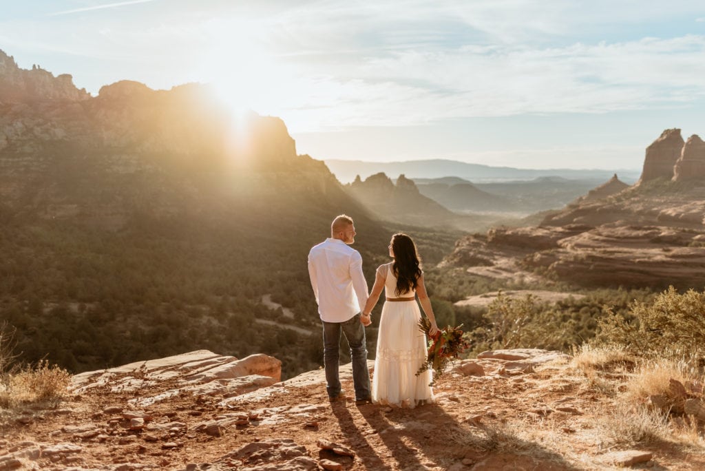 Bride and Groom holding hands overlooking the red rock canyons of Sedona, Arizona
