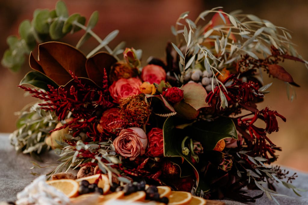 Red, orange, yellow, and deep burgundy wildflower wedding bouquet