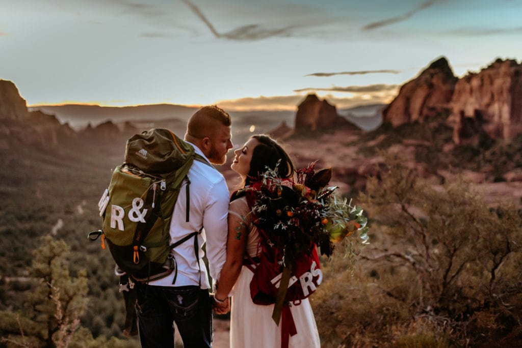 Couple in backpacks kiss during Sedona Sunset