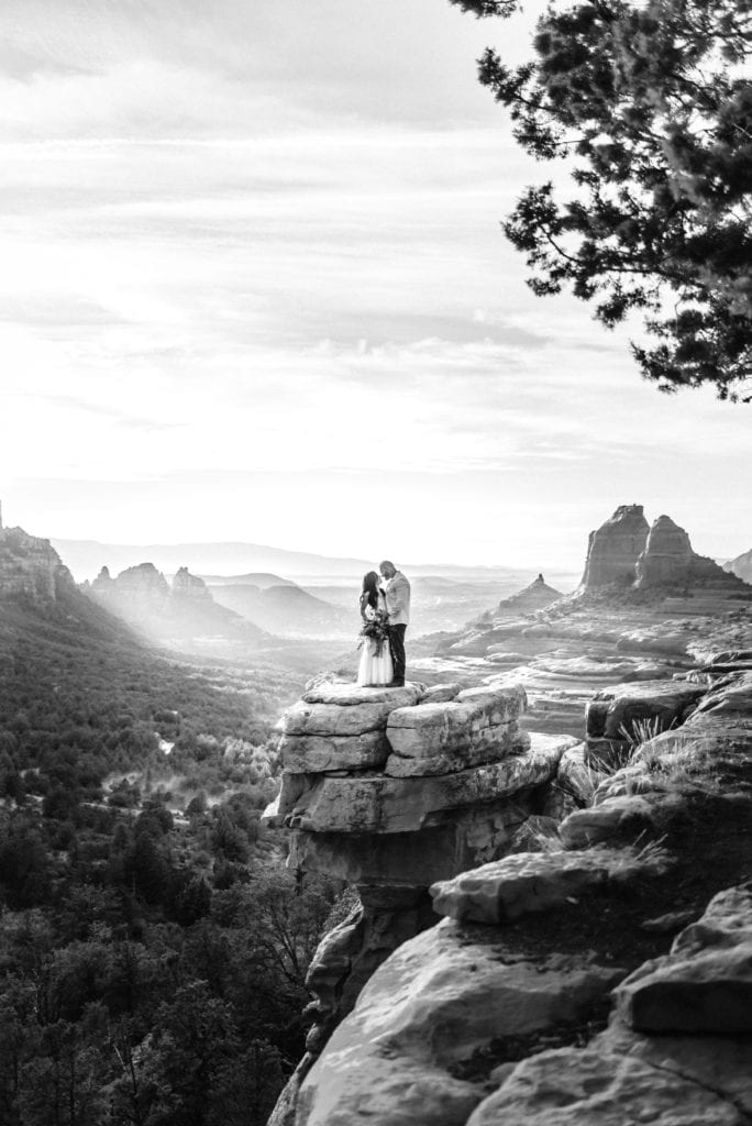 Dramatic black and white image of couple embracing at Carousel Rock in Sedona