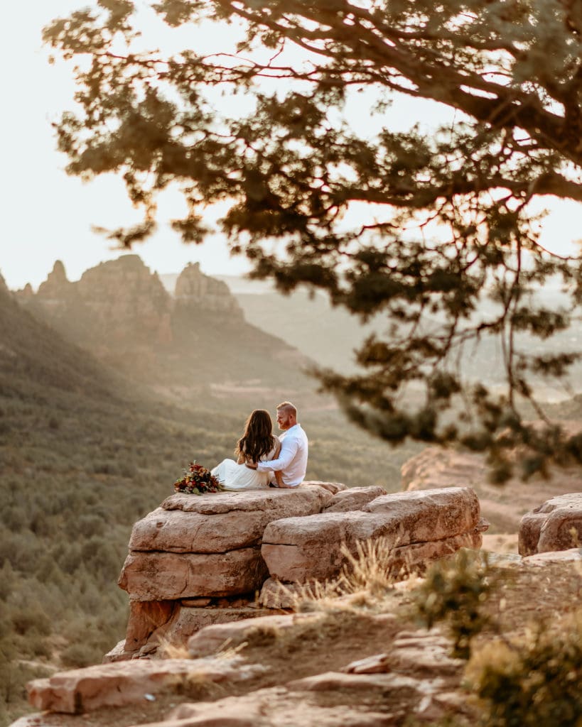 Wedding couple watching the sun set behind the mountains in Sedona, Arizona