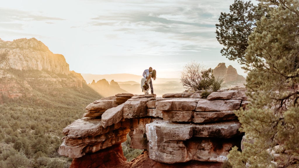 Groom dips bride into a kiss at Carousel Rock in Sedona