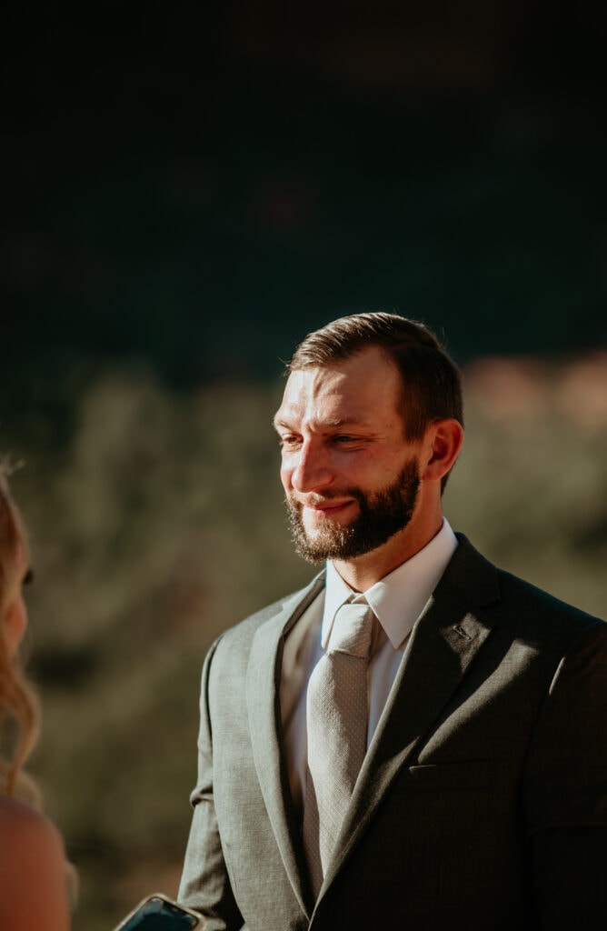 Groom looking lovingly at bride during their Sedona elopement ceremony