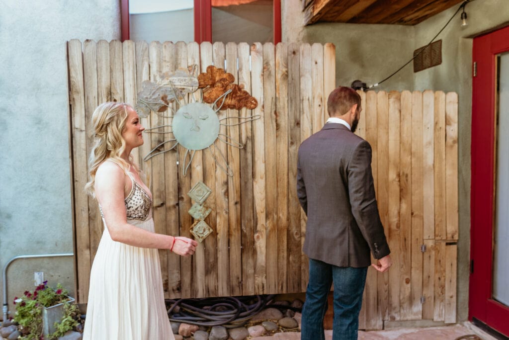 groom with his back to bride as they prepare for their first look