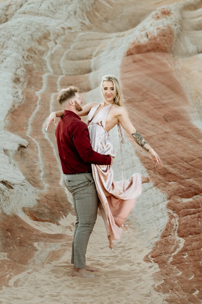 Nick holds Cassie up as she playfully kicks out her feet behind her