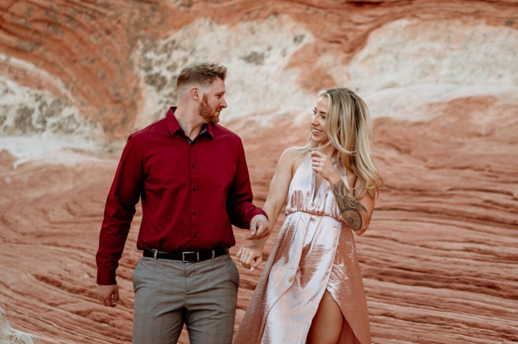 Couple walking hand in hand through a sandstone formation