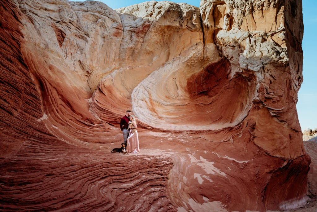 Engaged couple stand in the red sandstone during their Vermillion Cliffs engagement Session
