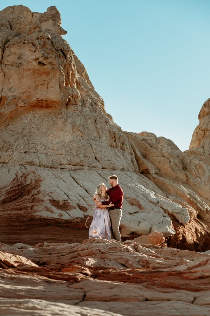 Nick embraces Cassie from behind surrounded by Vermillion Cliffs sandstone formations
