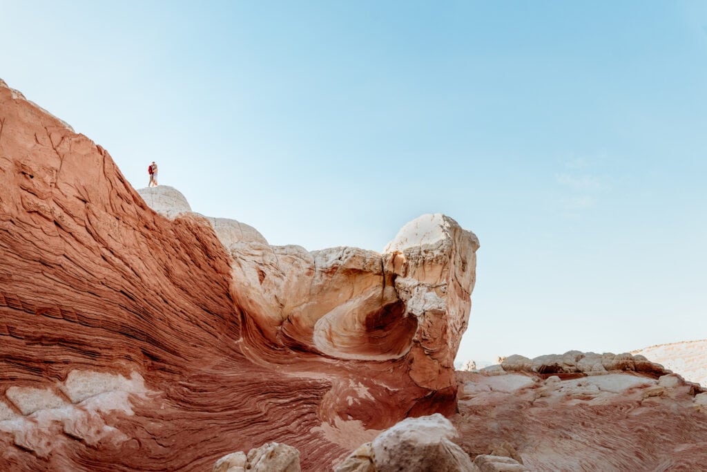 Couple embrace on top of one of the most iconic formations of the Vermillion Cliffs