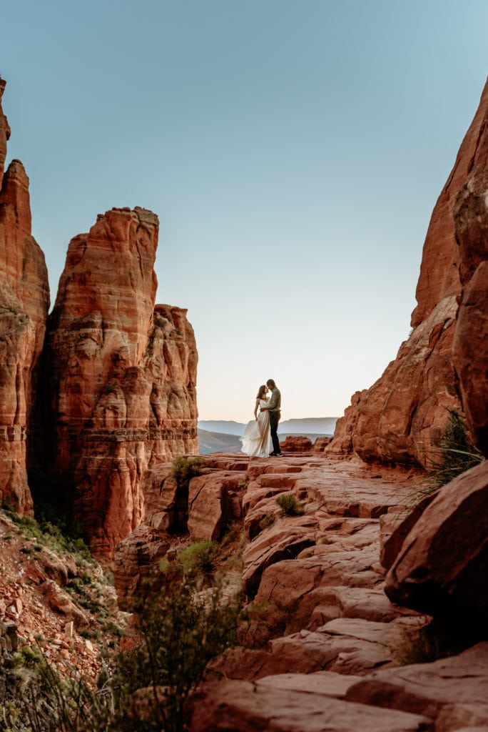 Couple embrace at the edge of the Cathedral Rock summit
