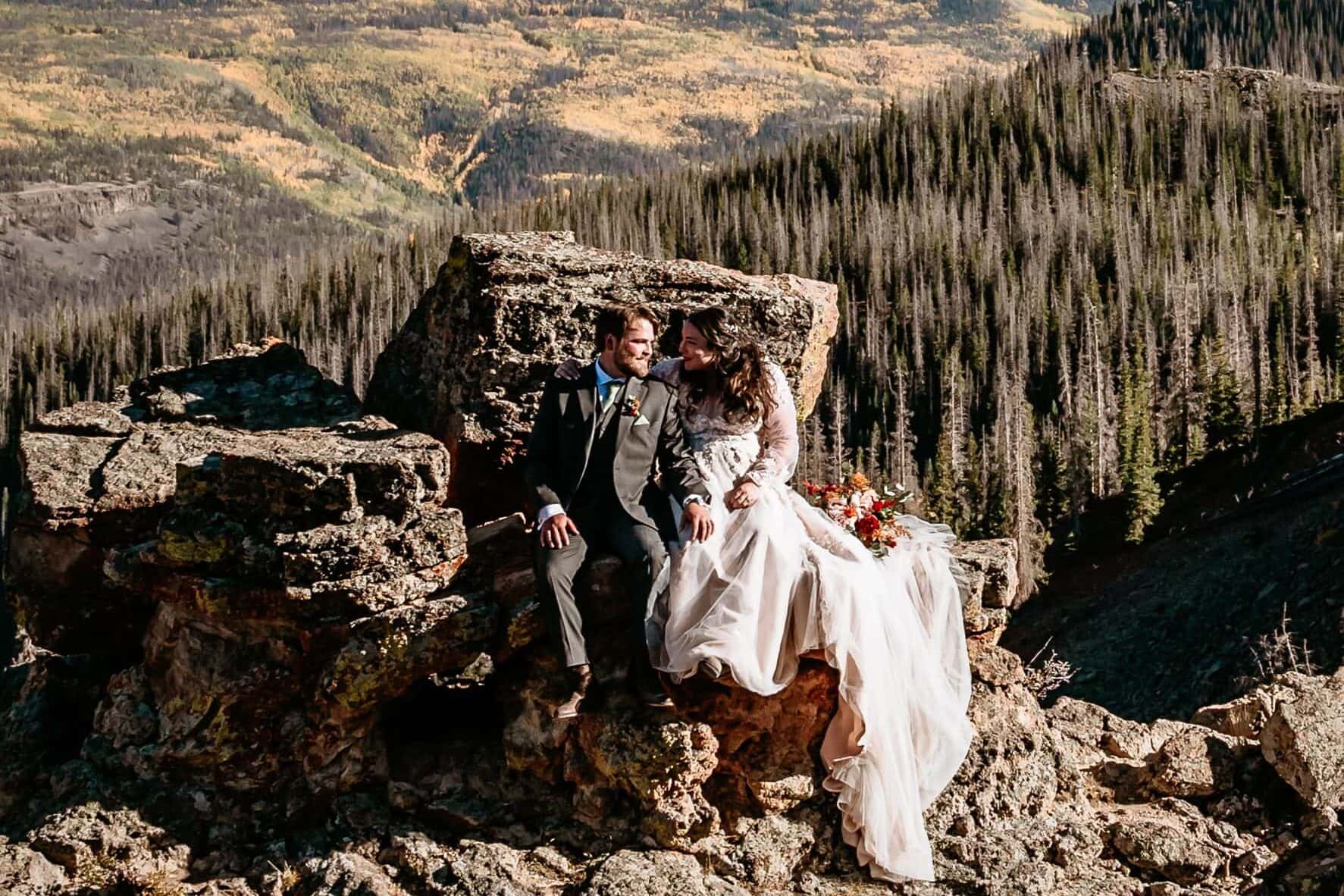 Couple sits atop a rocky ridge in the San Juan Mountains, photographed by San Juan Mountains Elopement Photographer Shannon Durazo