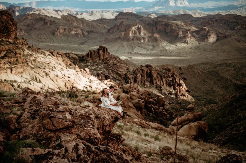 Couple sitting on a rocky ledge during their Phoenix elopement, shot by Stratus Adventure Photography