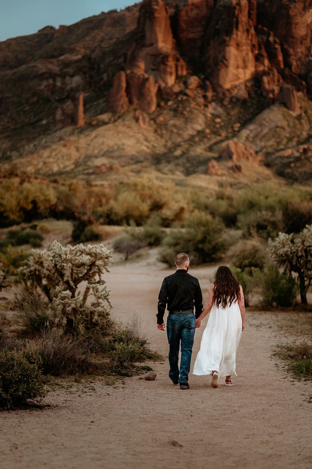 Couple walking towards the Superstition Mountains during their Phoenix elopement, shot by Stratus Adventure Photography
