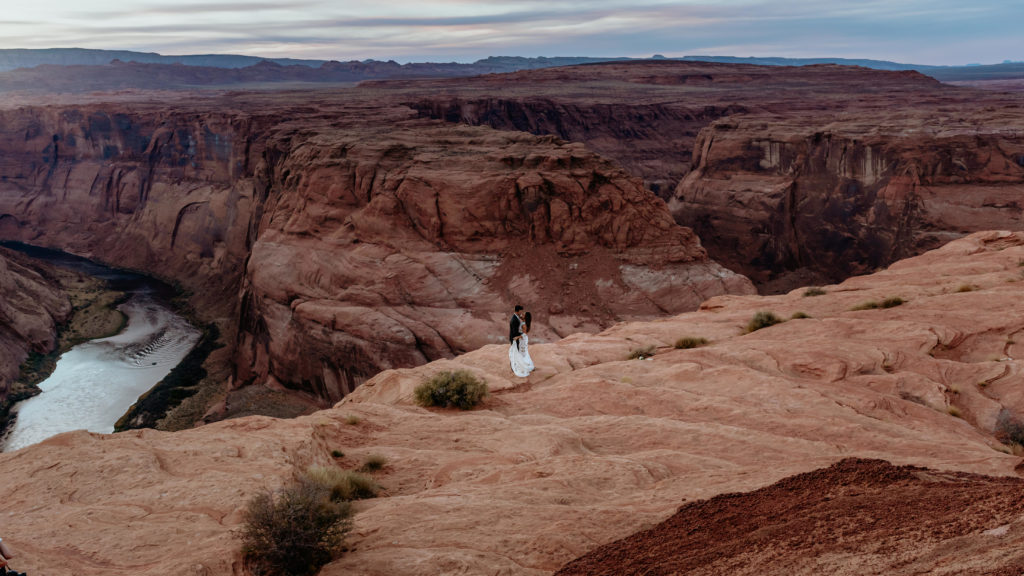 Wide view of couple looking down on the Colorado River